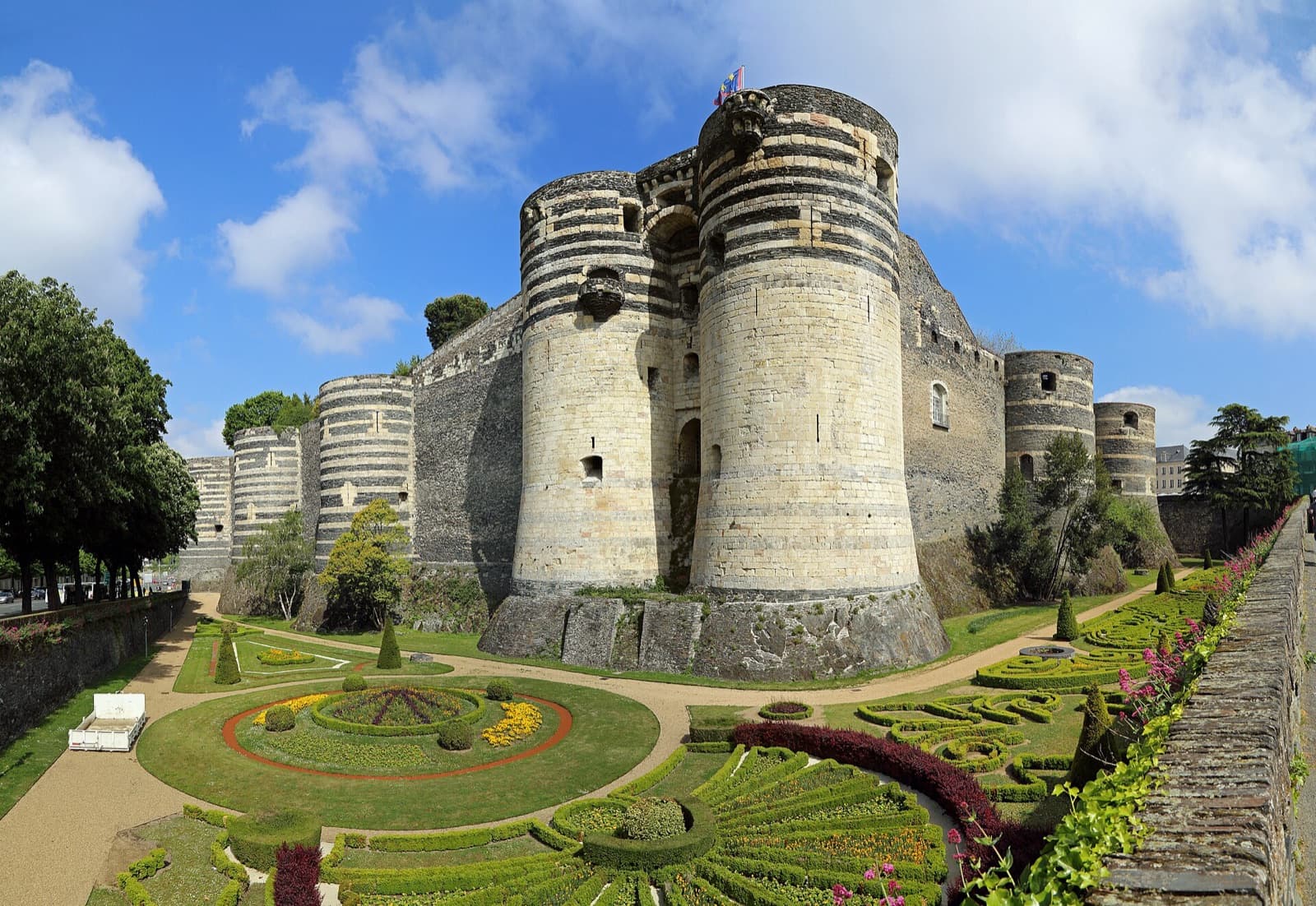 Le château d’Angers, ses tours rayées d’ardoise et de tuffeau, et les jardins à ses pieds